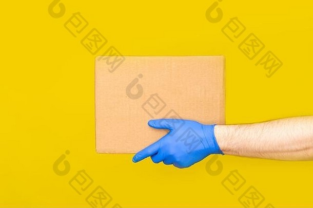 关闭手交付男人。医疗手套持有空纸板盒子黄色的工作室背景服务冠状病毒在线购物模拟