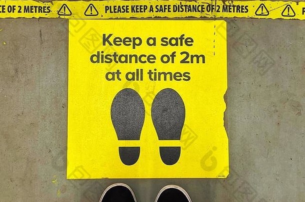 脚与标志地板上商店指导购物者维护社会距离