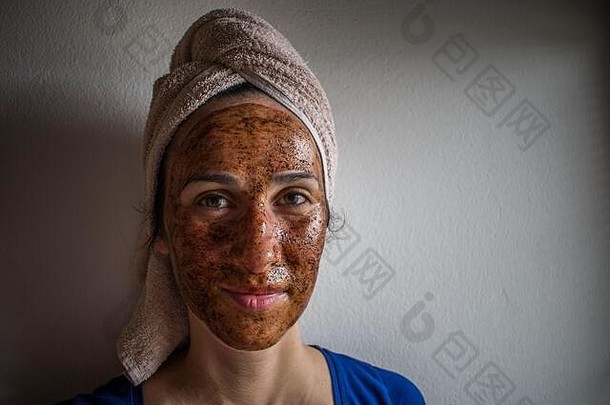 年轻的女人女孩女肖像应用化妆品脸面具毛巾敲头