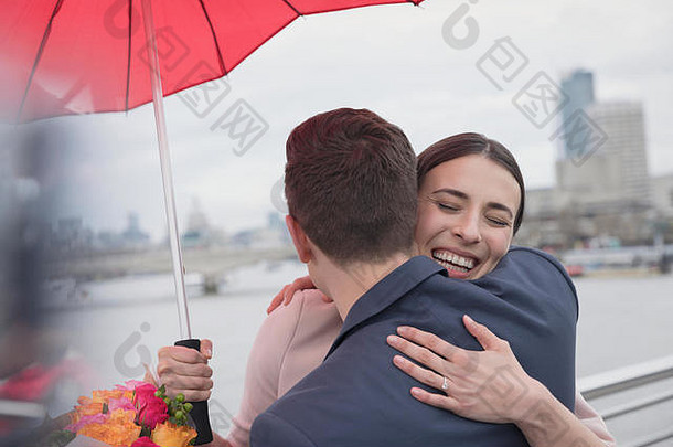 微笑充满深情的夫妇伞花拥抱城市桥伦敦