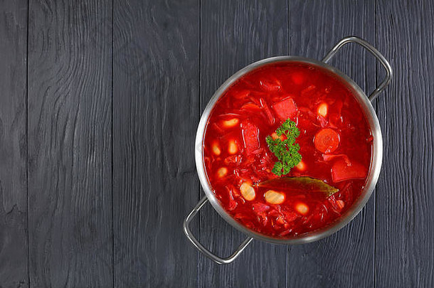 经典甜菜根红色的汤罗宋汤不锈钢钢砂锅锅黑色的木表格视图