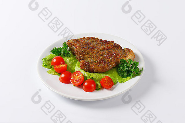 片烤猪肉肉蔬菜装饰白色板