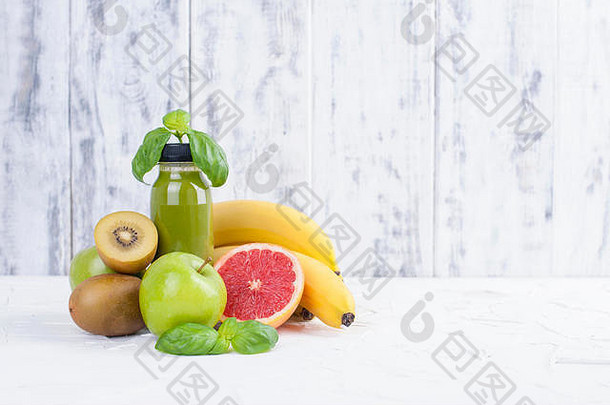 猕猴桃绿色苹果罗勒香蕉grapfruit汁塑料瓶排毒食物白色木背景复制spce