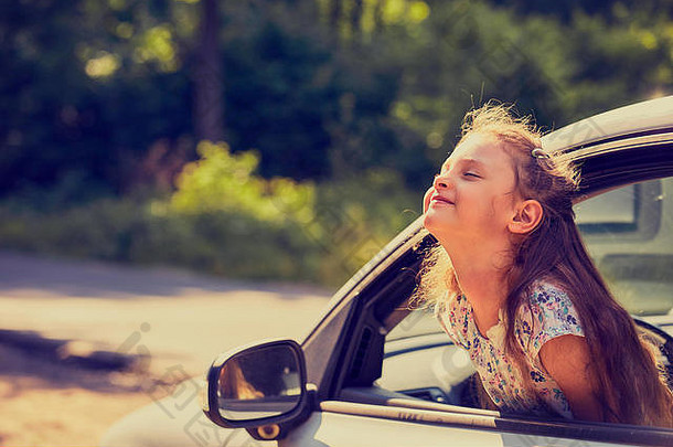 有趣的快乐享受旅行孩子女孩车窗口开放口夏天明亮的绿色自然背景特写镜头司机