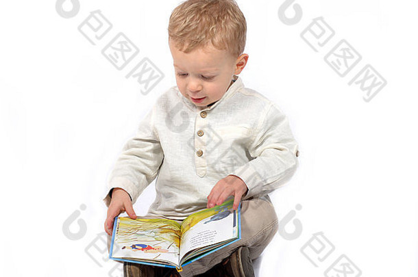 婴儿穿着白色衬衫坐着盘腿阅读书