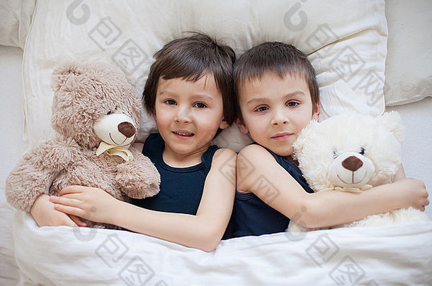 男孩泰迪熊说谎床上相机微笑