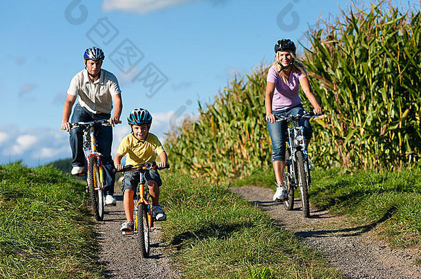 家庭骑自行车夏天妈妈。父亲儿子