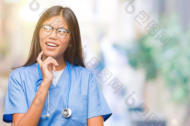 年轻的亚洲医生女人孤立的背景手下巴思考问题沉思的表达式微笑深思熟虑的脸怀疑