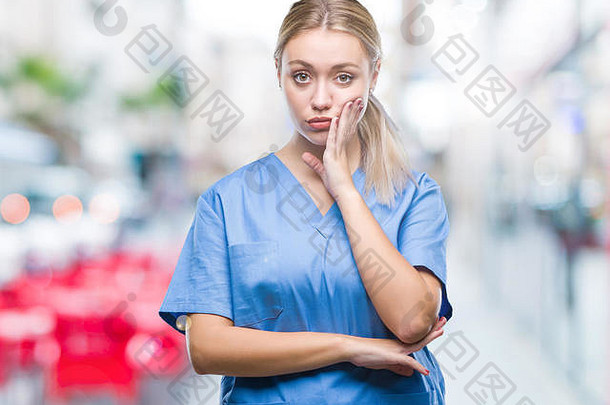 年轻的金发女郎外科医生医生女人穿医疗统一的孤立的背景思考累了无聊抑郁症问题横