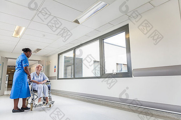 高级女女人病人轮椅坐着医院走廊非洲美国女护士