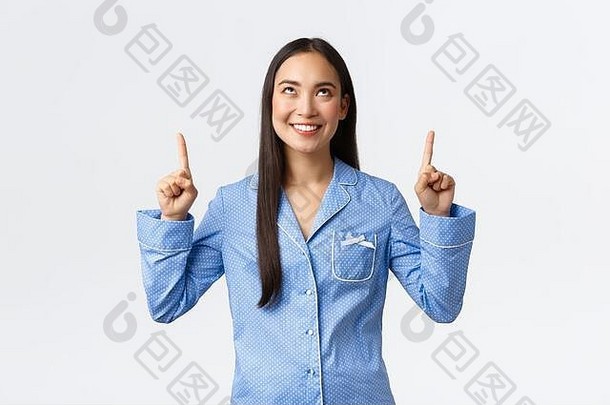 快乐满意亚洲女人蓝色的睡衣指出手指太棒了促销提供女孩睡衣在外过夜聚会，派对显示