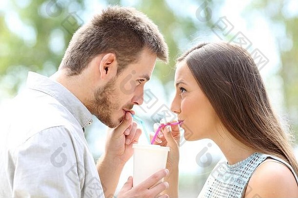 一边视图肖像夫妇喝着外卖喝吸管
