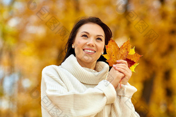 快乐年轻的女人枫木叶子秋天公园
