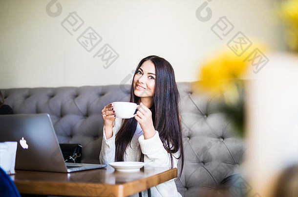 年轻的漂亮的女人咖啡馆喝咖啡
