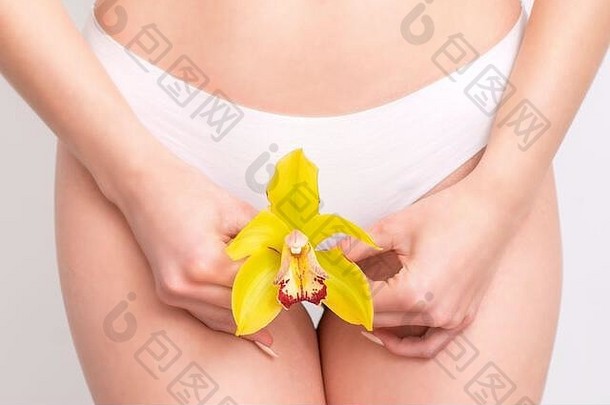 女人持有黄色的花穿着白色内裤白色背景关闭