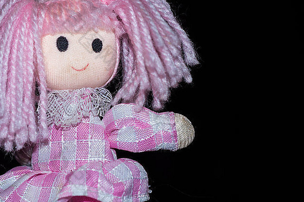 粉红色的拼接而成羊毛娃娃笔指出平原黑色的背景