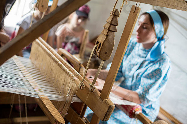 女人编织色彩斑斓的棉花袍衣服木织机当地的村俄罗斯