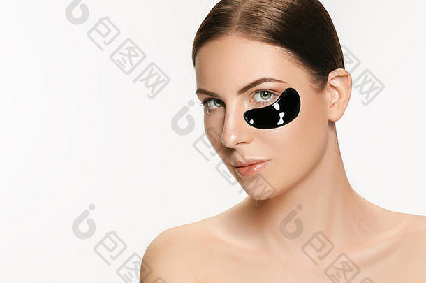年轻的美丽的女人应用面具脸治疗黑色的泥水疗中心治疗