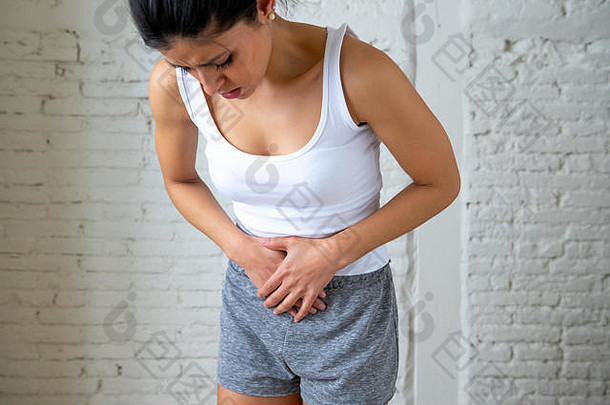 关闭年轻的女人痛苦的胃痛持有手肚子身体疼痛胃炎便秘期疼痛月经抽筋