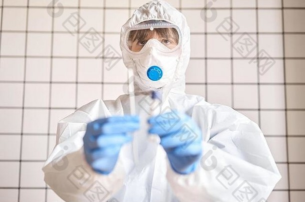 医生持有拭子测试管法律顾问分析冠状病毒测试蓝色的医疗手套保护脸面具保护新冠病毒