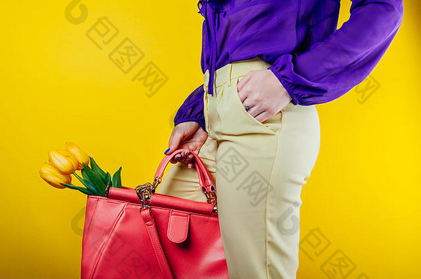 工作室拍摄女人穿春天装持有袋黄色的郁金香黄色的背景