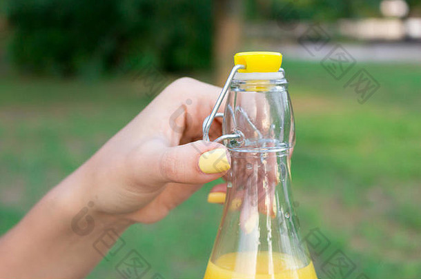 裁剪图像女孩持有开放瓶新鲜的汁