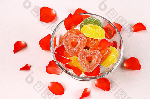 彩色的糖果红色的心玻璃碗玫瑰花瓣前视图