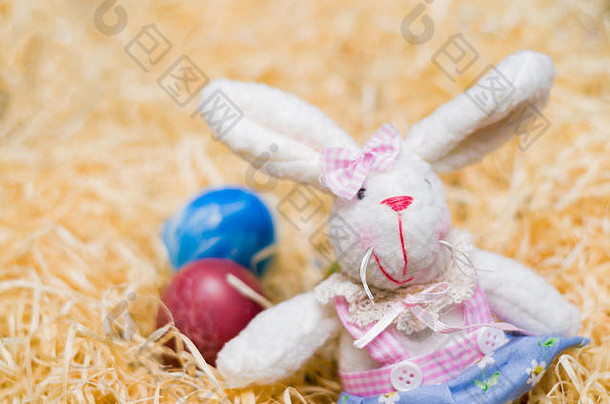 概念复活节豪华的复活节兔子稻草背景装饰色彩斑斓的鸡蛋