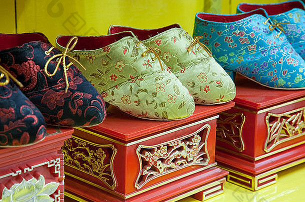 特写镜头拍摄漂亮的装饰可爱洋娃娃鞋子绑定脚中国人传统唐人街马六甲海峡马来西亚