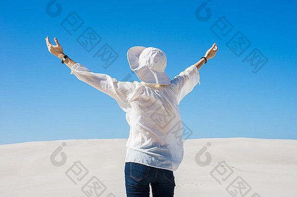 女人提升手空气站沙子沙丘