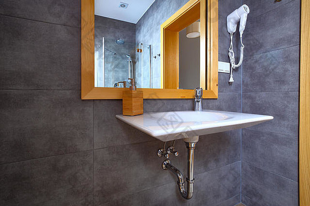 白色闪亮的水槽镜子浴室灰色的瓷砖墙室内现代浴