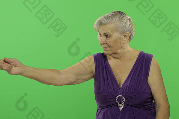 上了年纪的女人点展示开放手棕榈微笑漂亮的祖母紫色的衣服的地方标志文本浓度关键绿色屏幕背景