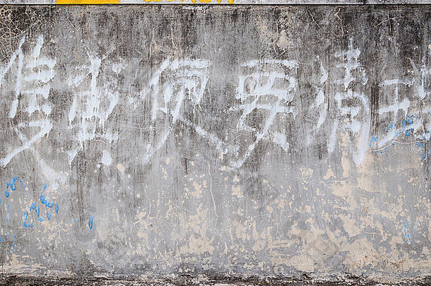 饱经风霜的岁的灰色混凝土墙纹理背景褪了色的中国人写作
