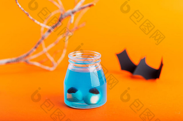 万圣节概念人工眼睛蓝色的液体橙色背景蝙蝠分支机构背景