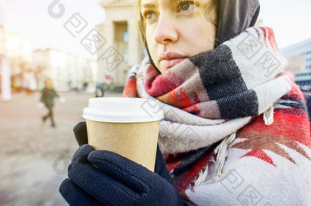 年轻的美丽的女孩手套大舒适的围巾持有纸杯外卖咖啡城市环境咖啡冬天概念