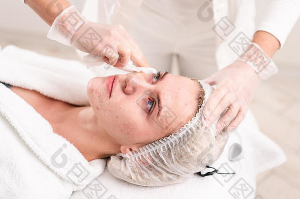 医生删除过来这里病人脸应用治疗奶油反痤疮光疗美丽的女人照片复兴过程脸皮肤治疗化妆品诊所