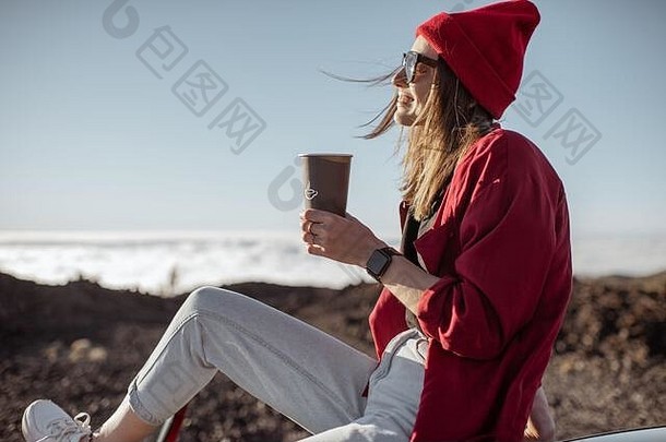 生活方式肖像时尚的女人坐着<strong>咖啡</strong>杯车屋顶享受美丽的日落云