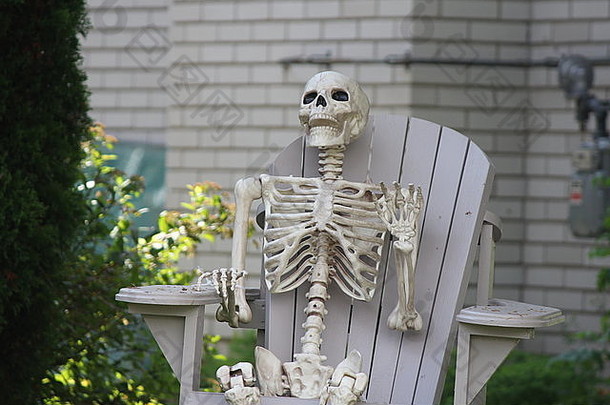 塑料装饰模仿人类骨架坐着院子里椅子准备万圣节