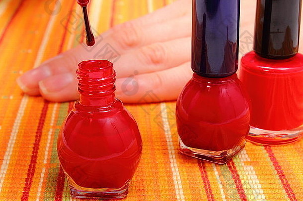 女人应用红色的指甲波兰的修剪整齐的指甲女人指甲护理