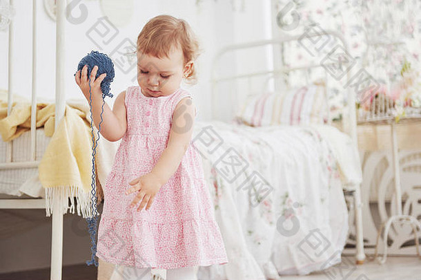 童年概念婴儿女孩可爱的衣服玩彩色的线程白色古董childroom