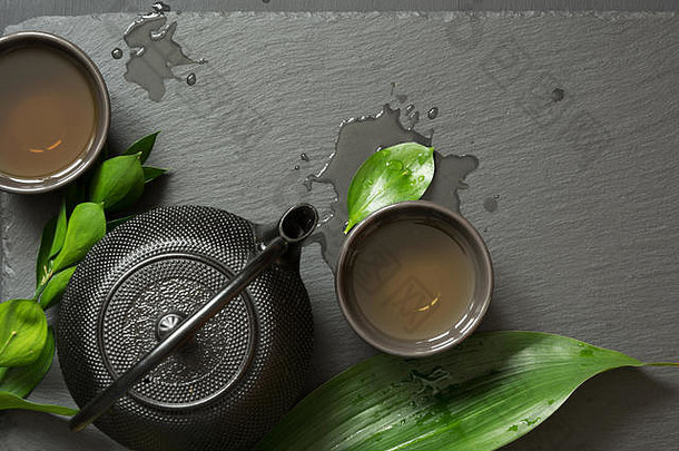 绿色茶黑色的板岩板仪式黑色的茶壶碗绿色茶前视图复制空间