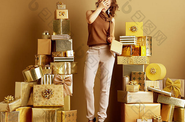 强调优雅的女人黄金米色裤子棕色（的）上衣金笔记本覆盖脸手桩金礼物前面