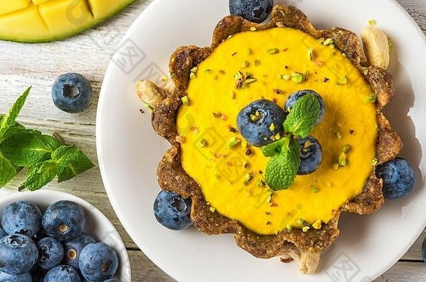 素食主义者食物甜点生素食主义者黄色的芒果蛋糕<strong>新鲜</strong>的<strong>蓝莓</strong>开心果薄荷健康的美味的谷蛋白<strong>免</strong>费的食物前视图