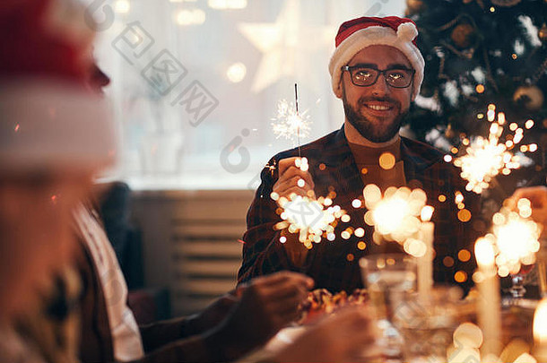 肖像快乐的有胡子的男人。穿圣诞老人他享受圣诞节庆祝活动餐厅朋友家庭