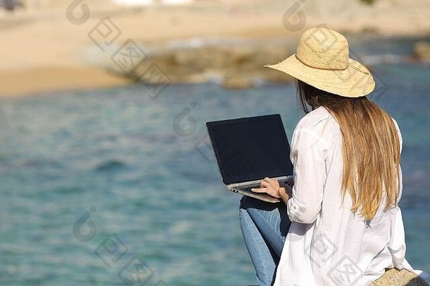回来视图女人穿帕梅拉打字移动PC海背景海滩