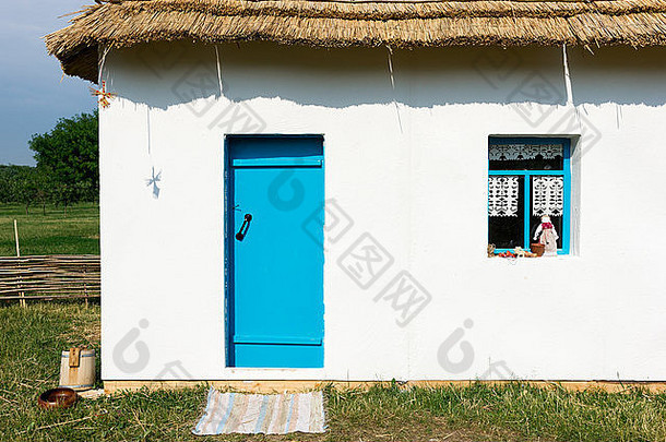 白色墙国家农民房子蓝色的通过窗口裹着毡子花盆线圈绳子窗台上