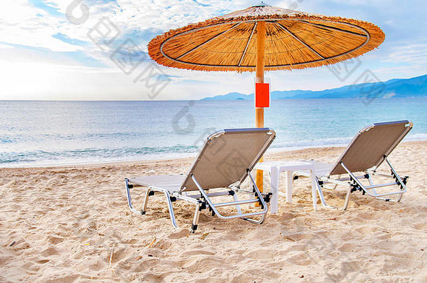 灰色的稻草伞美丽的海滩海洋燃烧太阳