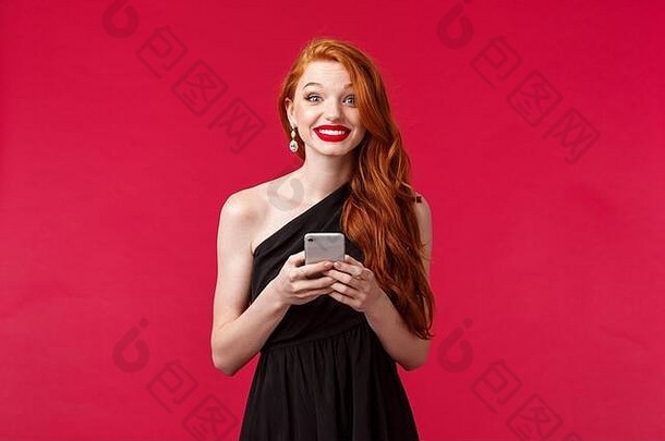 肖像兴奋逗乐红色头发的人女人穿黑色的衣服日期毕业舞会晚上持有移动电话微笑喜气洋洋的相机站