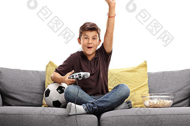 快乐的孩子玩足球视频游戏庆祝目标坐着沙发孤立的白色背景