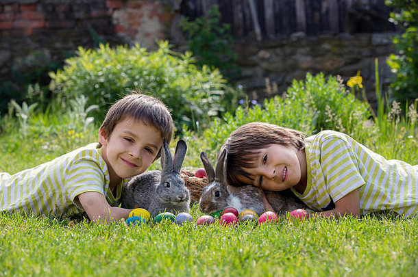 可爱的孩子玩兔子复活节鸡蛋盛开的花园春天男孩玩兔子蛋狩猎假期